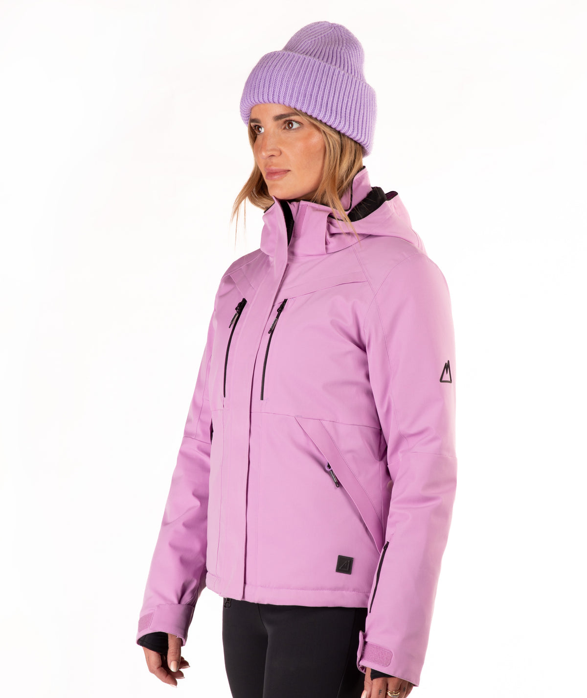 A woman wearing a light purple/lavender ski jacket and a matching knit beanie against a plain white studio background.
