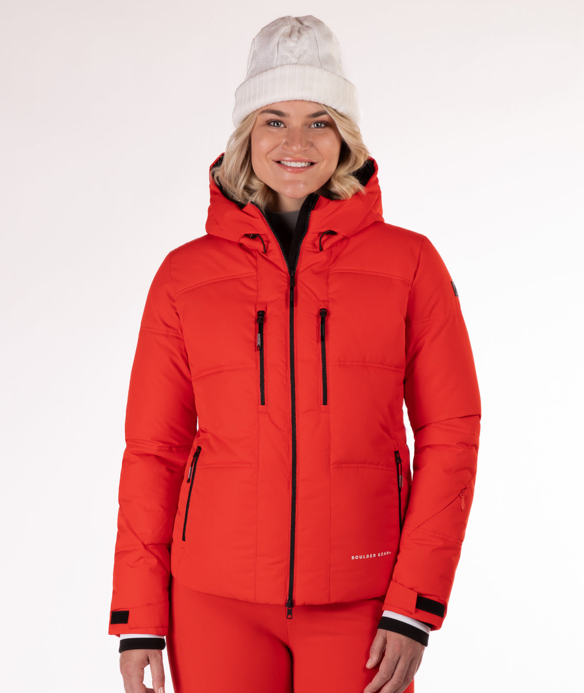 Woman wearing a red quilted winter jacket on a white background