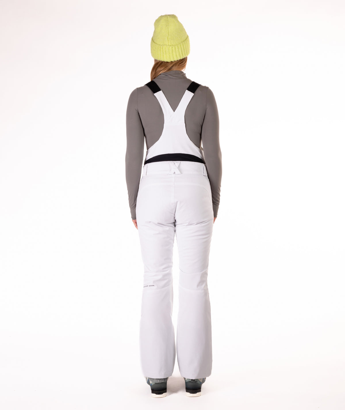 Back of person wearing a white snow bib overalls on a white background.