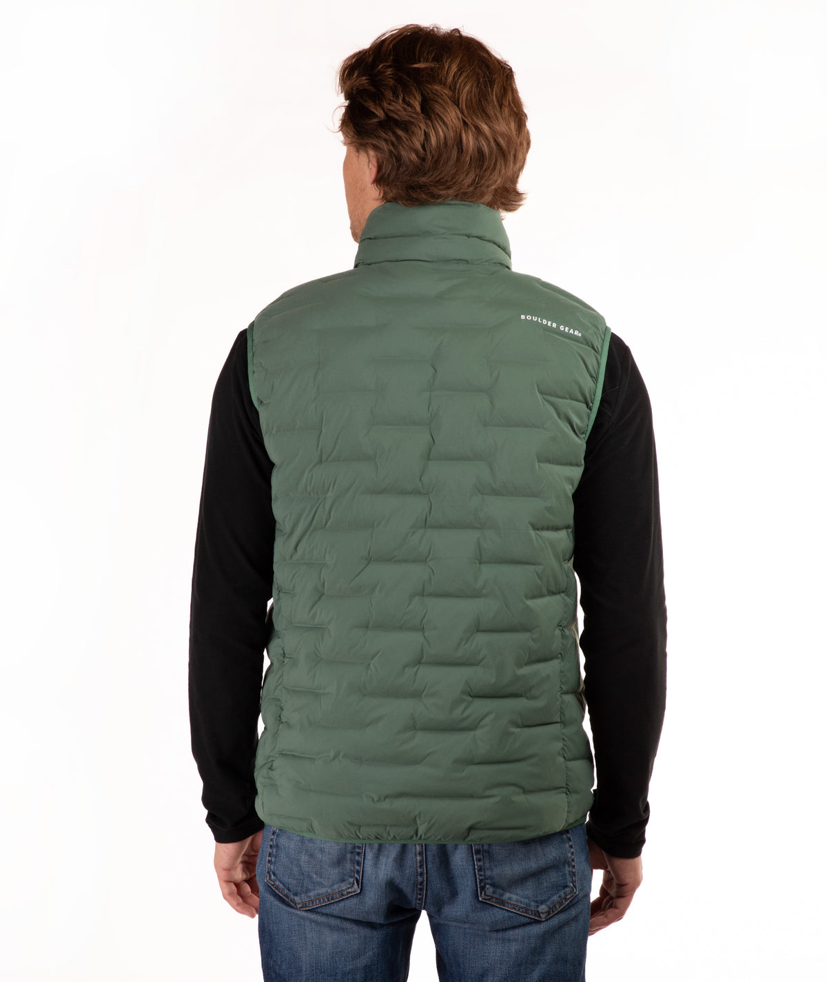 A man viewed from behind wearing a green quilted puffer vest over a black long-sleeve shirt and blue jeans, against a plain white background.