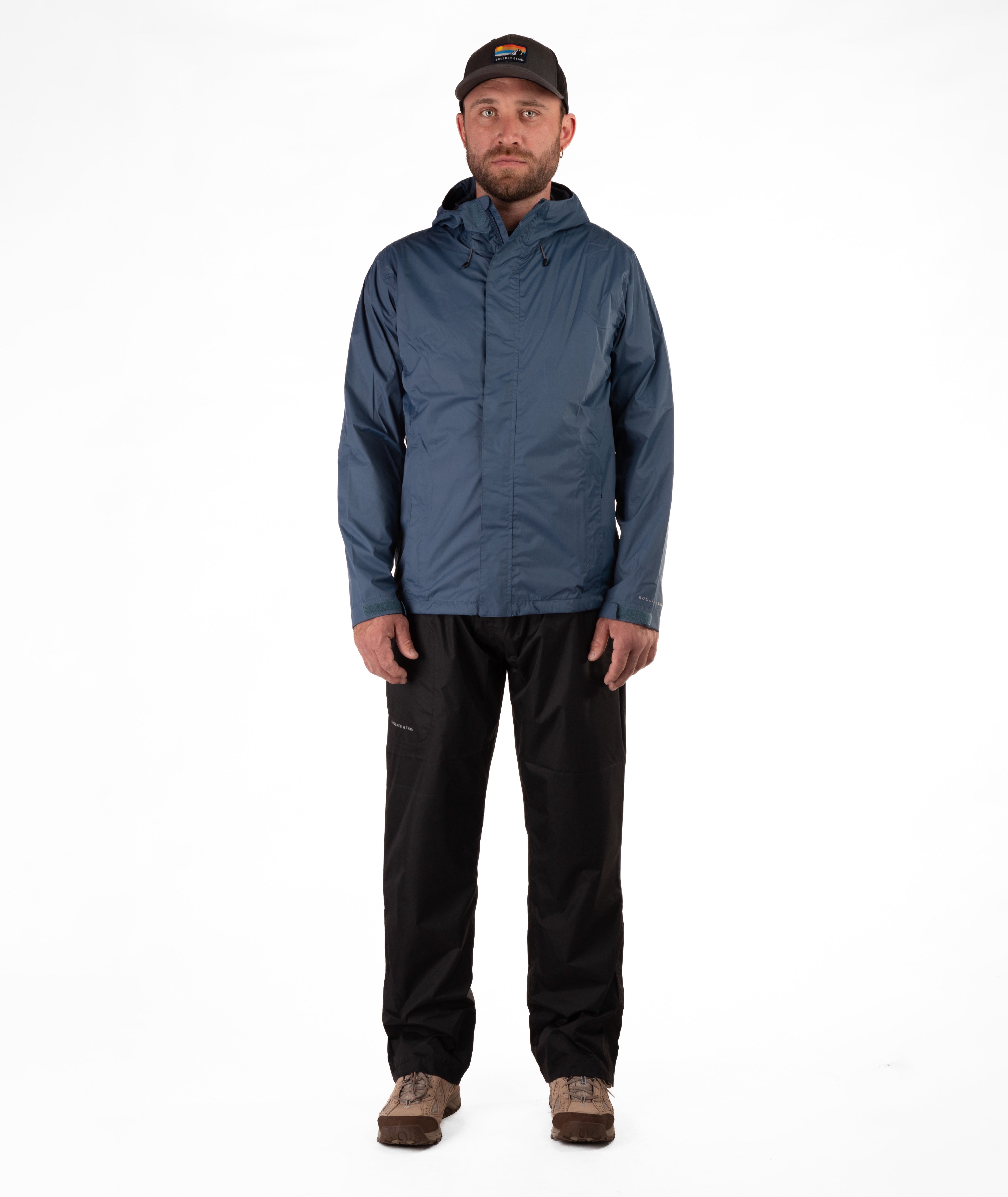 Man wearing a blue raincoat and black rain pants on a white background