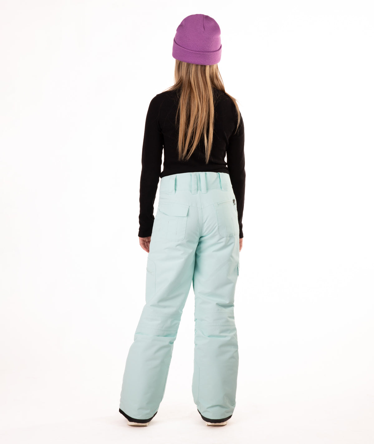 back of a girl wearing light blue snow pants and a black long-sleeve top on a white background