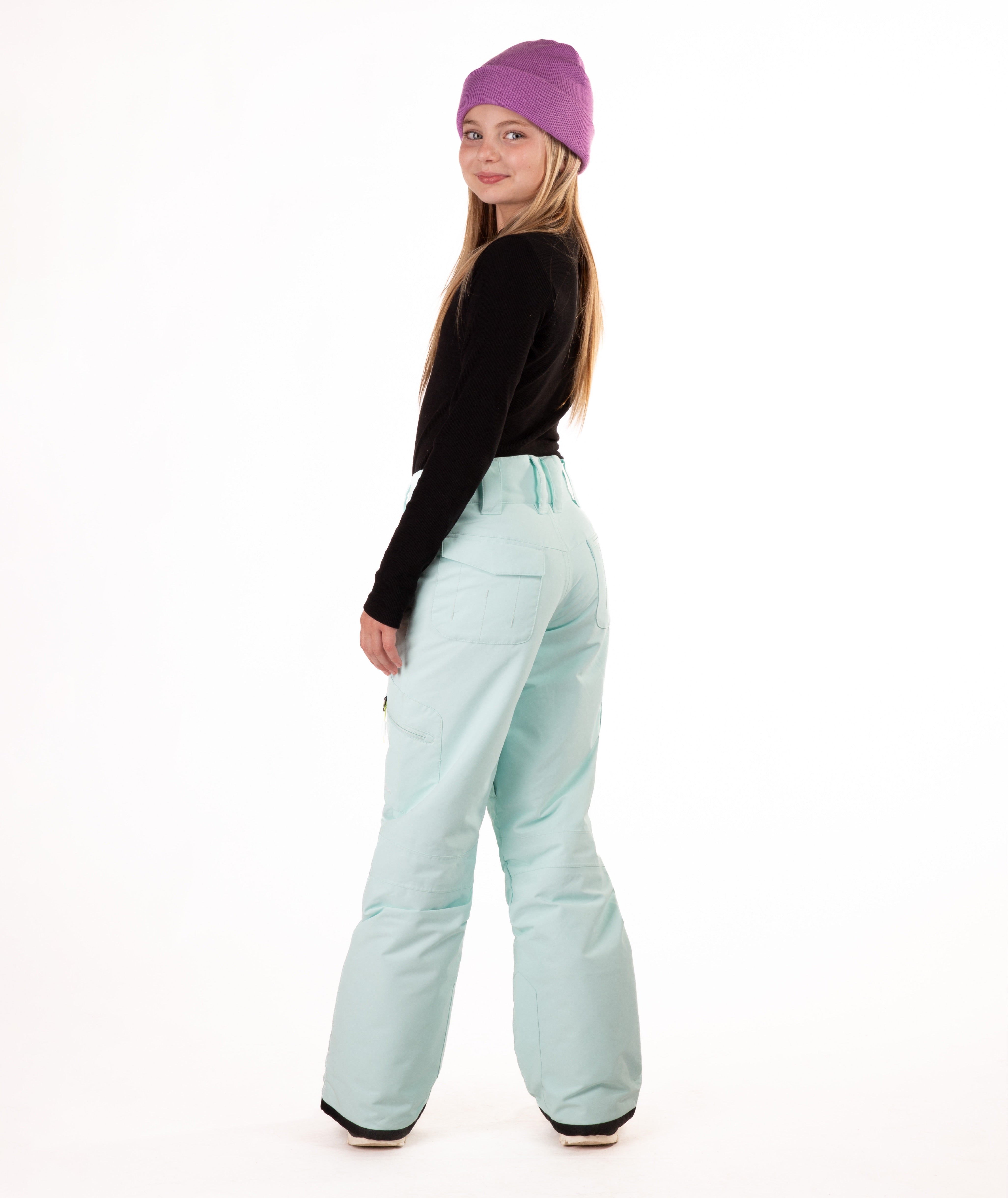 back of a girl wearing light blue snow pants and a black long-sleeve top on a white background
