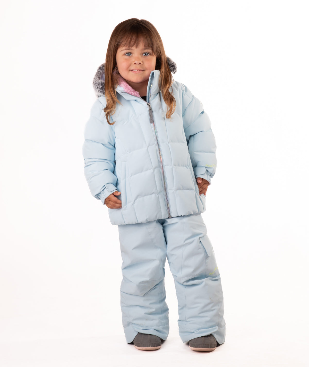 Child wearing a light blue quilted puffy winter coat on a white background