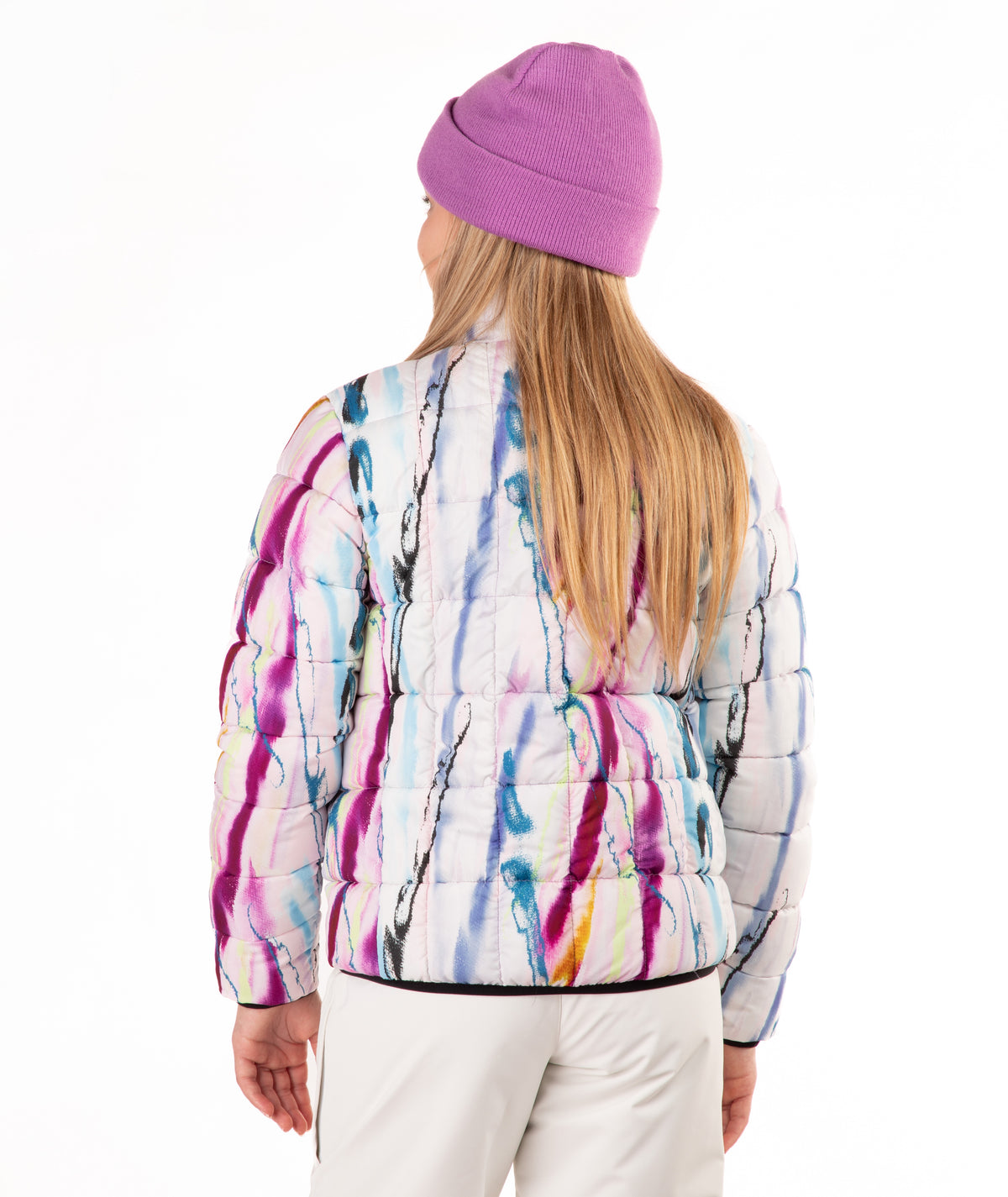 A girl shown from the back wearing a white quilted puffer jacket with a colorful paint-splatter pattern in purple, blue, pink, and yellow, paired with a purple knit beanie and white pants, against a plain white background.