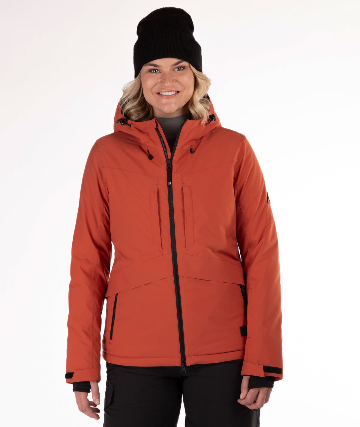 Woman wearing a rust colored winter jacket on a white background