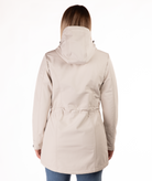 back of beige parka worn by a person on a white background