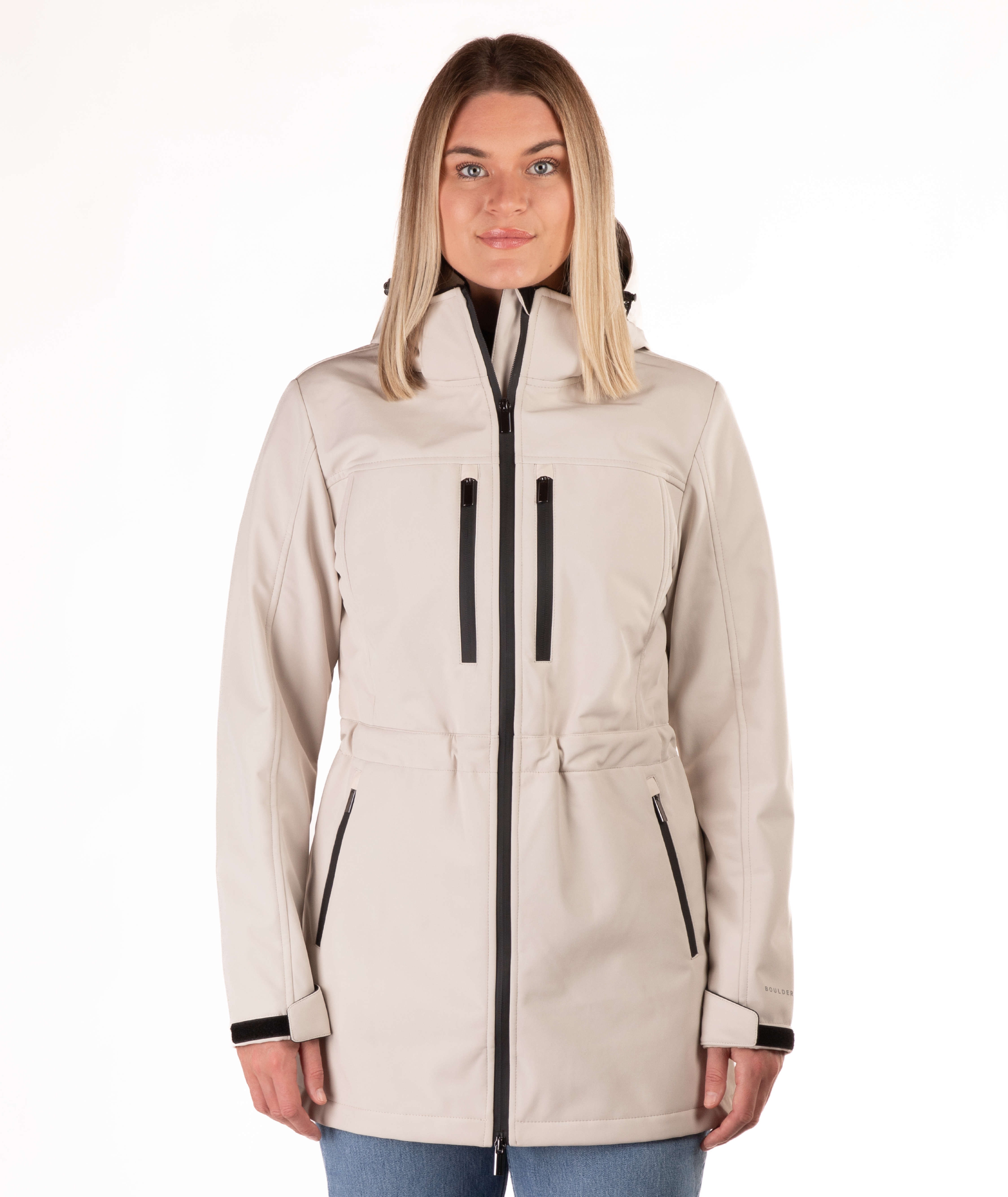 Woman wearing a beige jacket with black accents on a white background