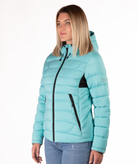 Woman wearing a light blue puffer jacket with black accents on a white background