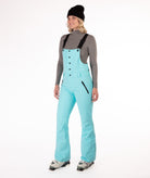 Person wearing a light blue snow bib overalls on a white background.