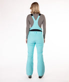 Back of person wearing a light blue snow bib overalls on a white background.