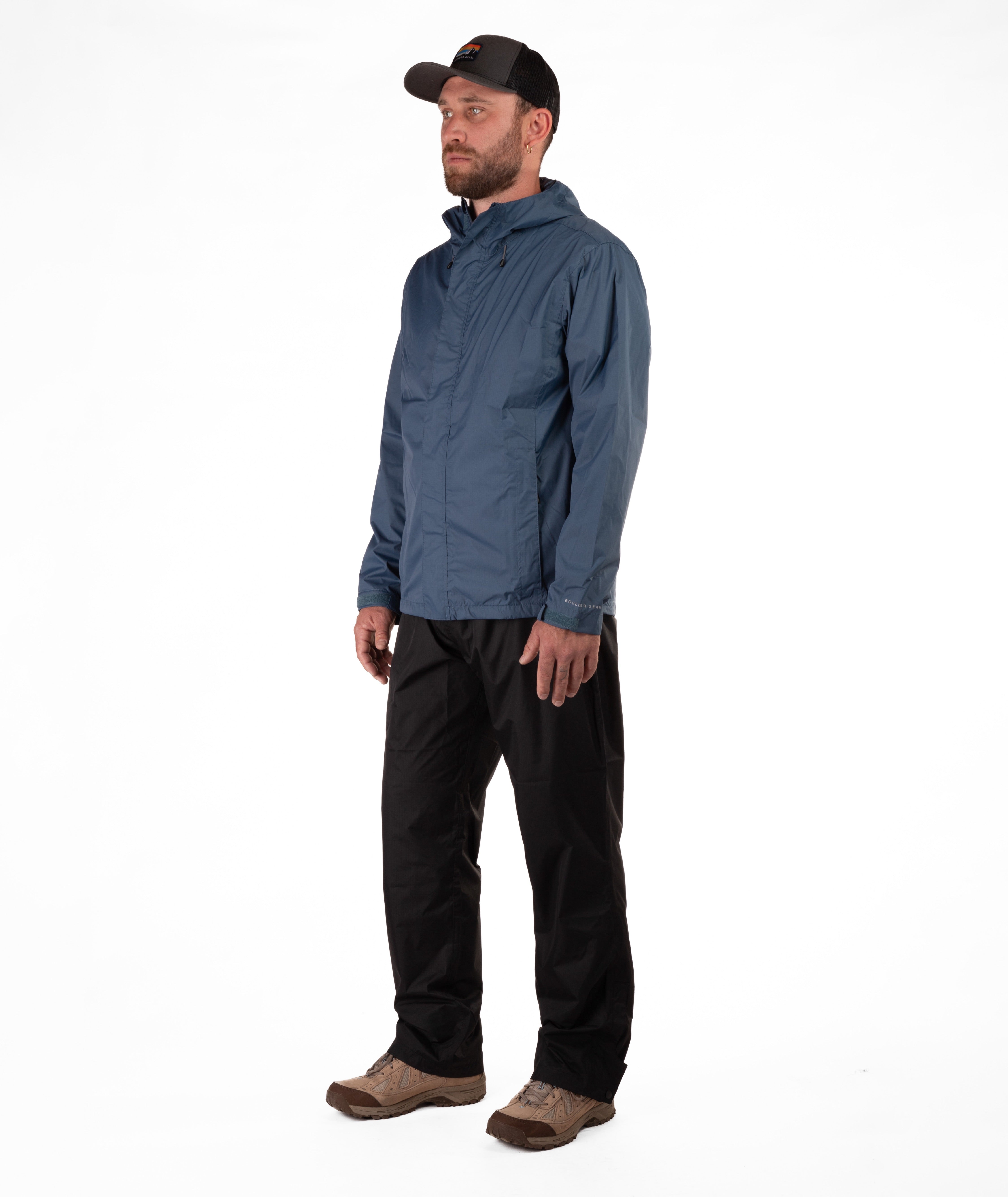 Man wearing a blue raincoat and black rain pants on a white background