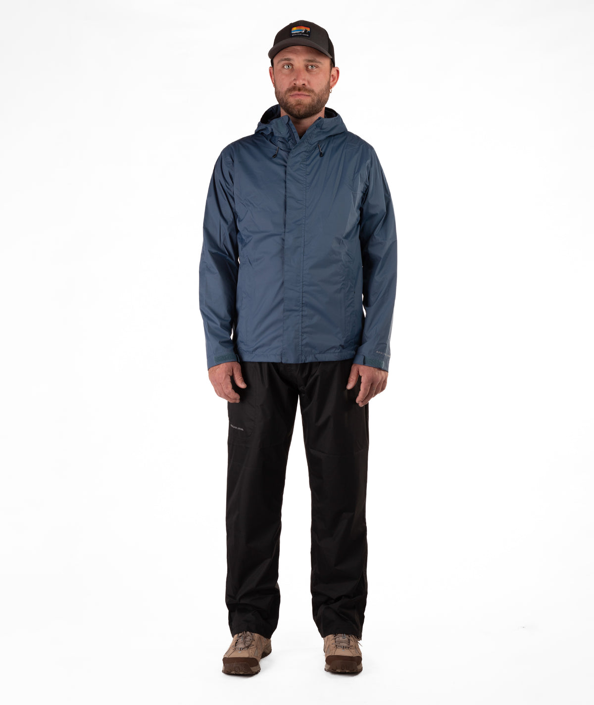 Man wearing a blue raincoat and black rain pants on a white background