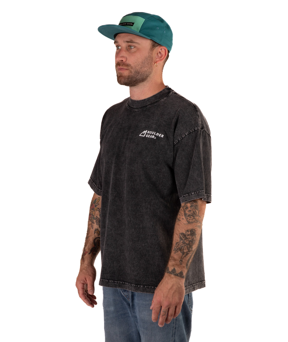Man wearing a faded black t-shirt with a logo and a green cap on a white background