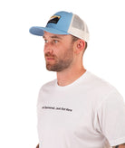 Man wearing a blue cap and white t-shirt with text on a white background