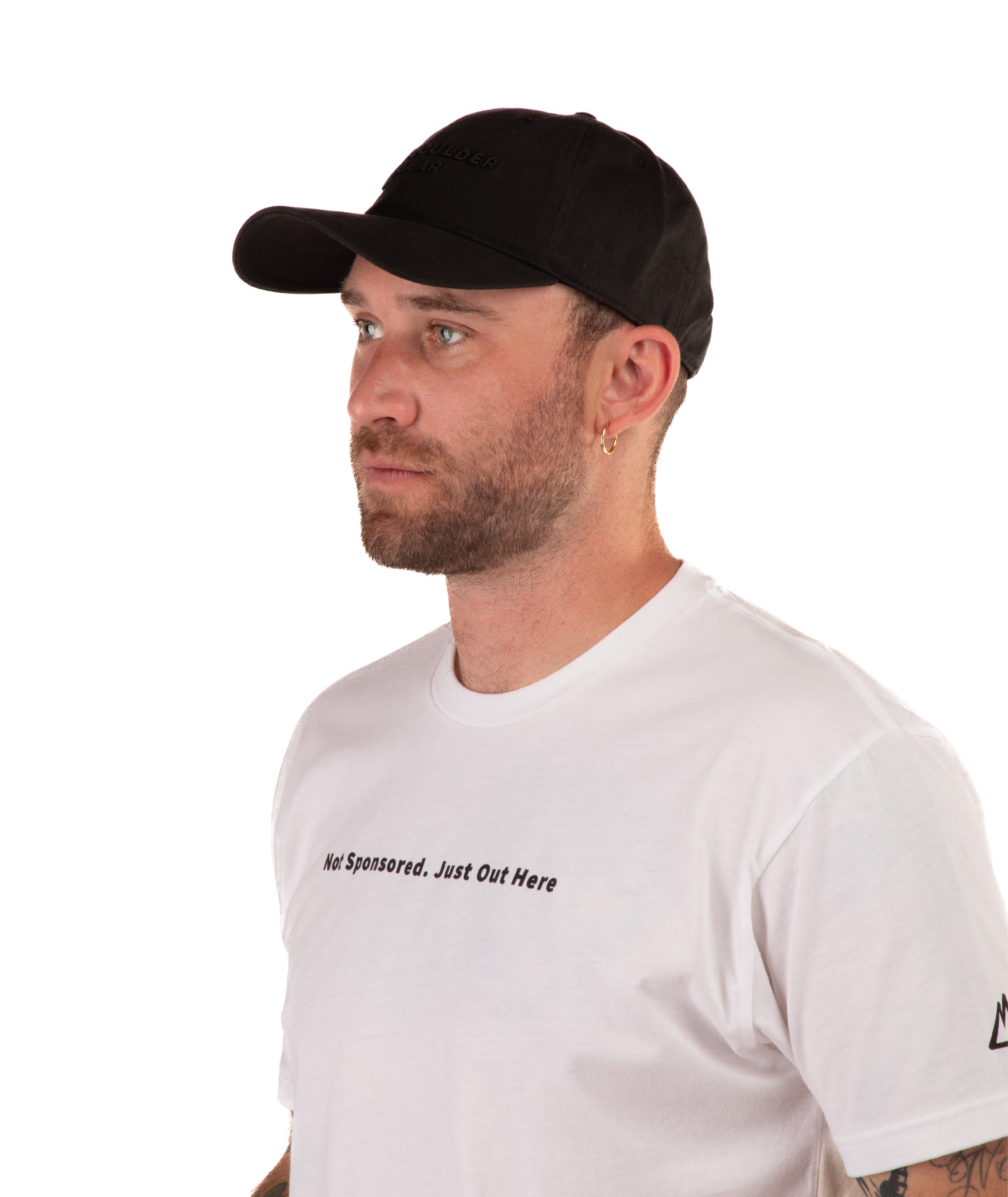 Man wearing a white t-shirt with text 'Not Sponsored. Just Out Here' with a black cap on a white background