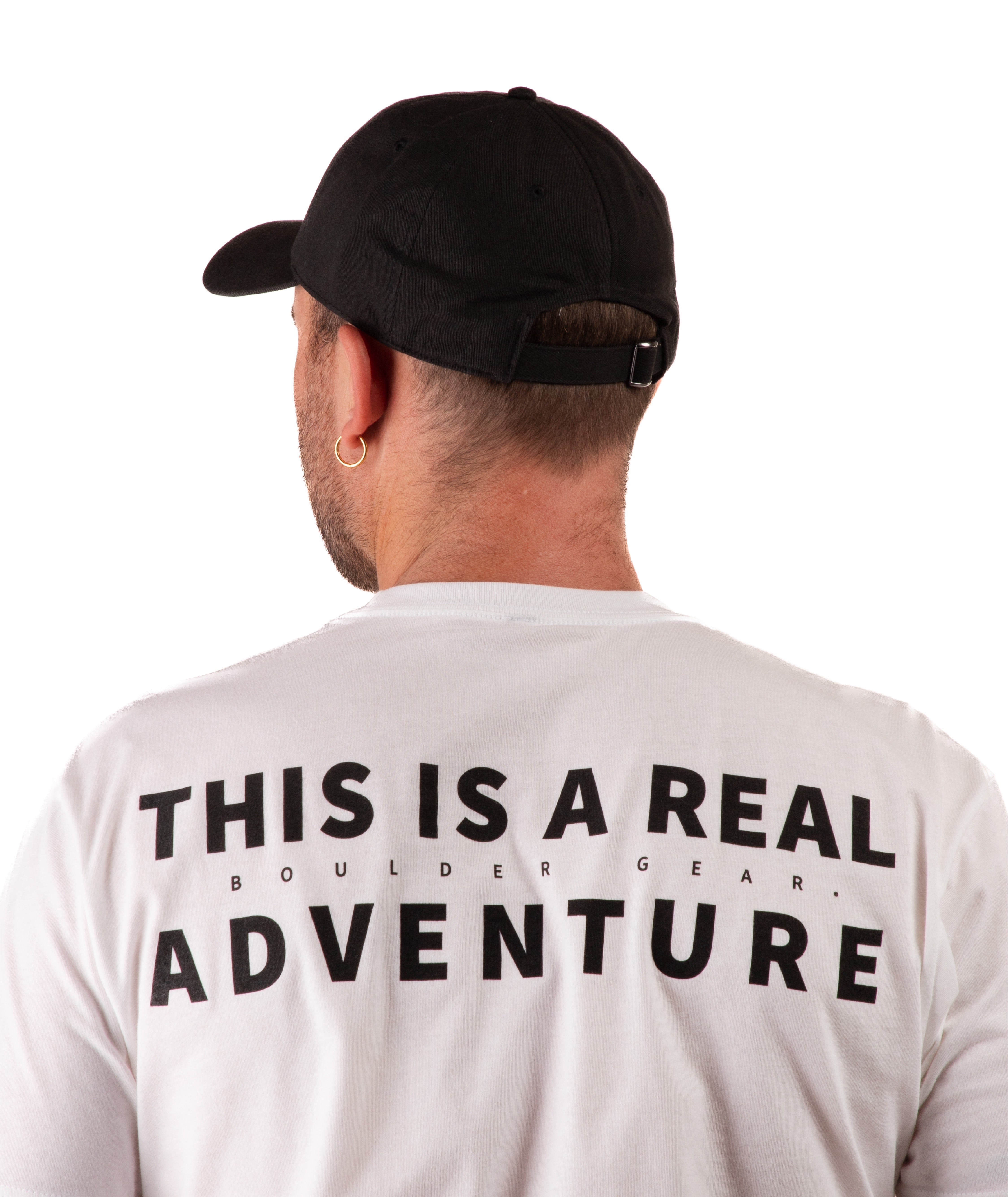 back of a Person wearing a white t-shirt with 'This is a Real Adventure' text on the back and a black cap, standing against a white background.