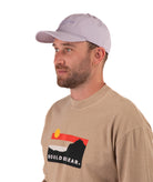 Man wearing a beige long-sleeve shirt with 'Boulder Gear' logo and a light purple cap on a white background