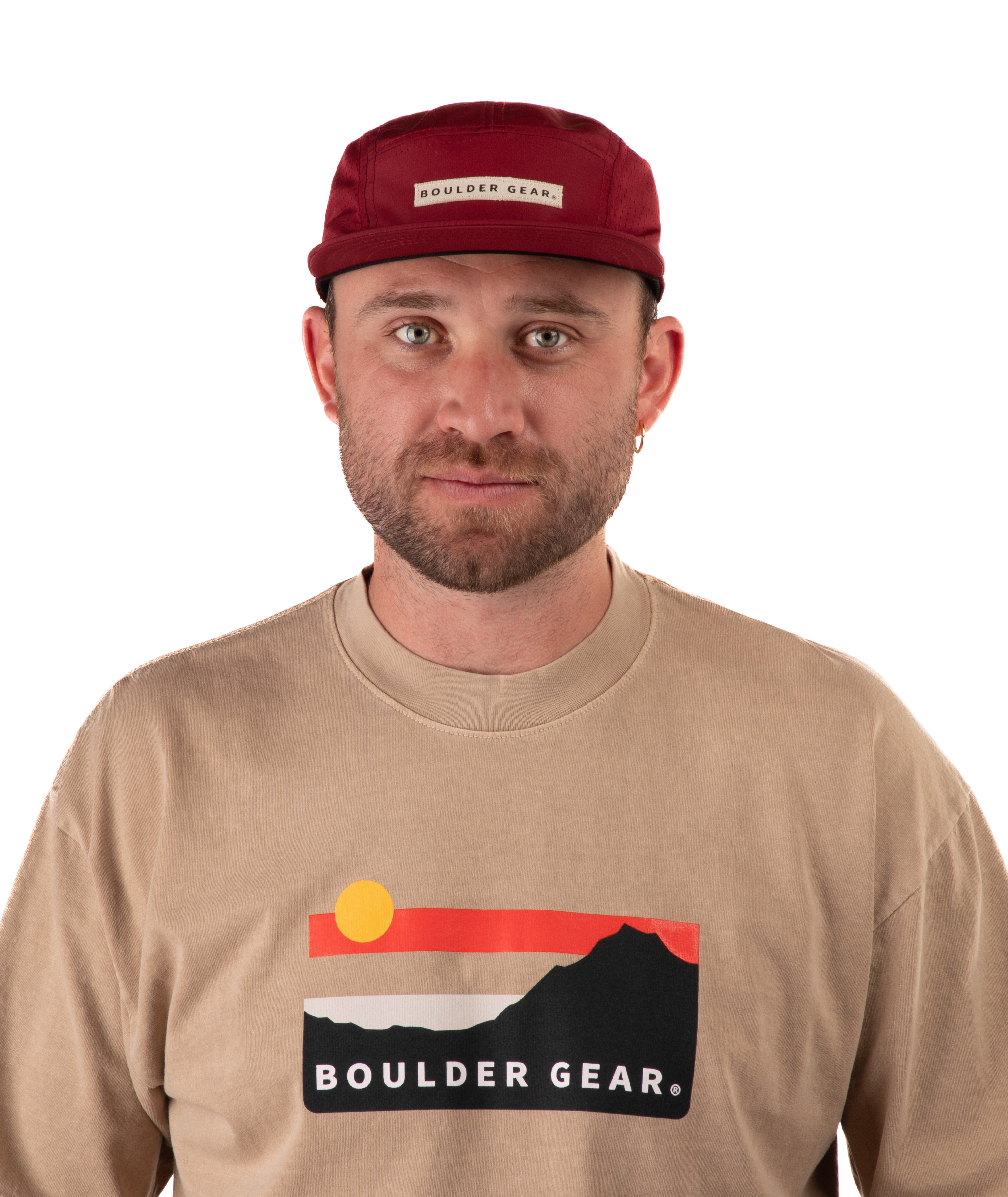 Man wearing a beige t-shirt with Boulder Gear logo and a maroon cap on a white background