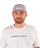 Man wearing a white t-shirt with text and a gray cap on a white background