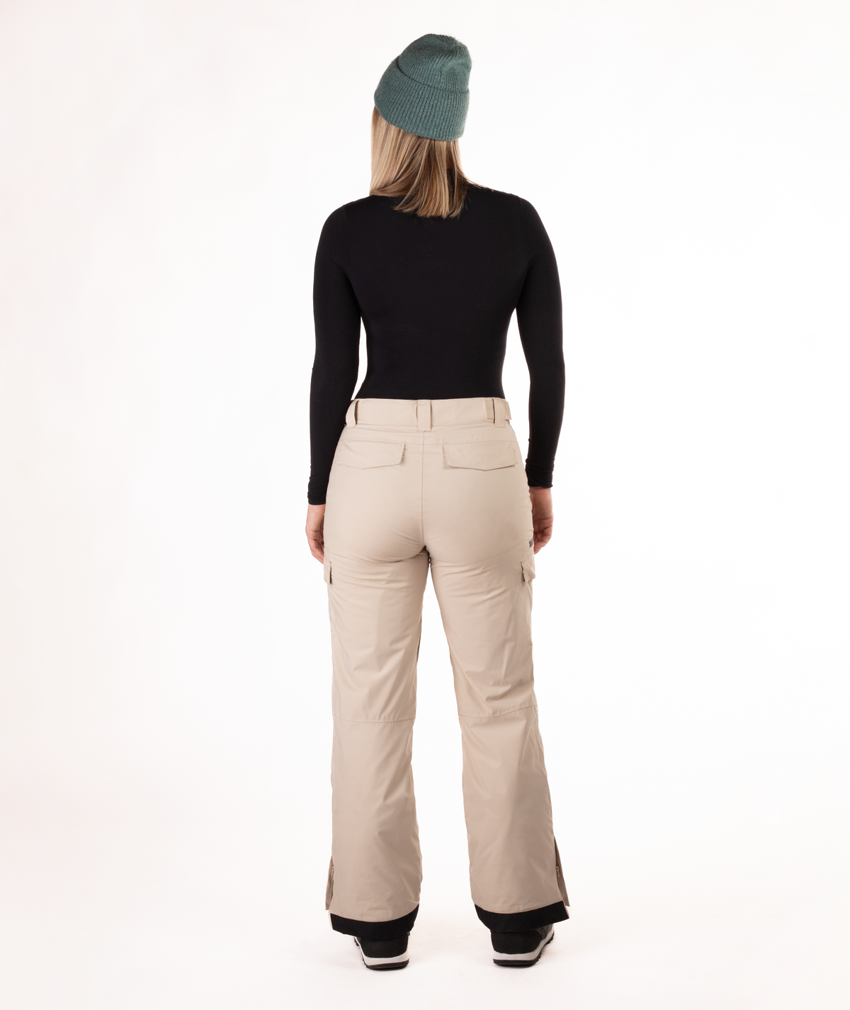back of person wearing a black long-sleeve top and beige snow pants on a white background