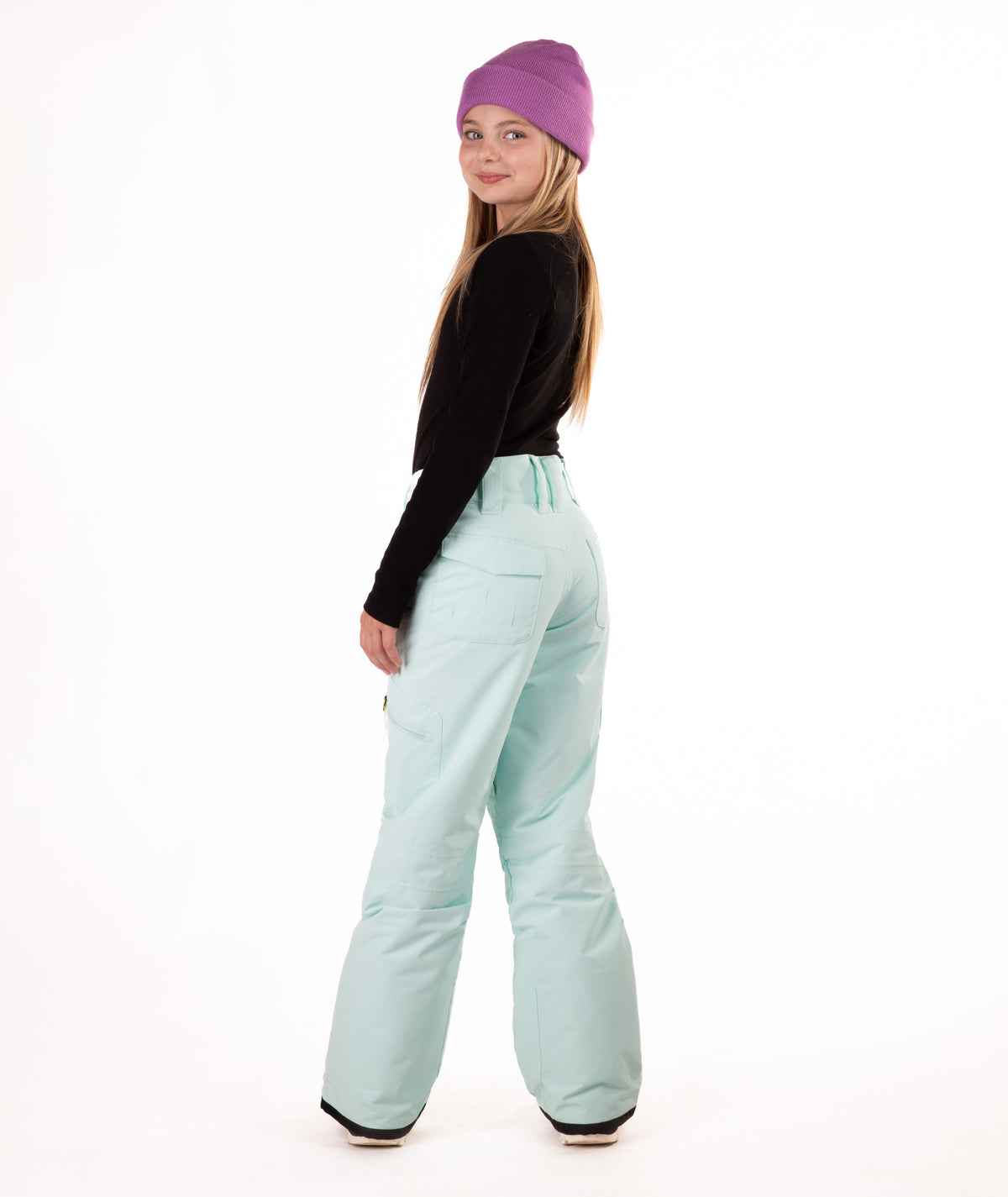 back of a girl wearing light blue snow pants and a black long-sleeve top on a white background