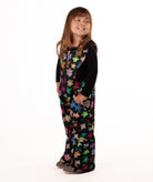 child wearing a multi color flower print snow bib with black top on a white background