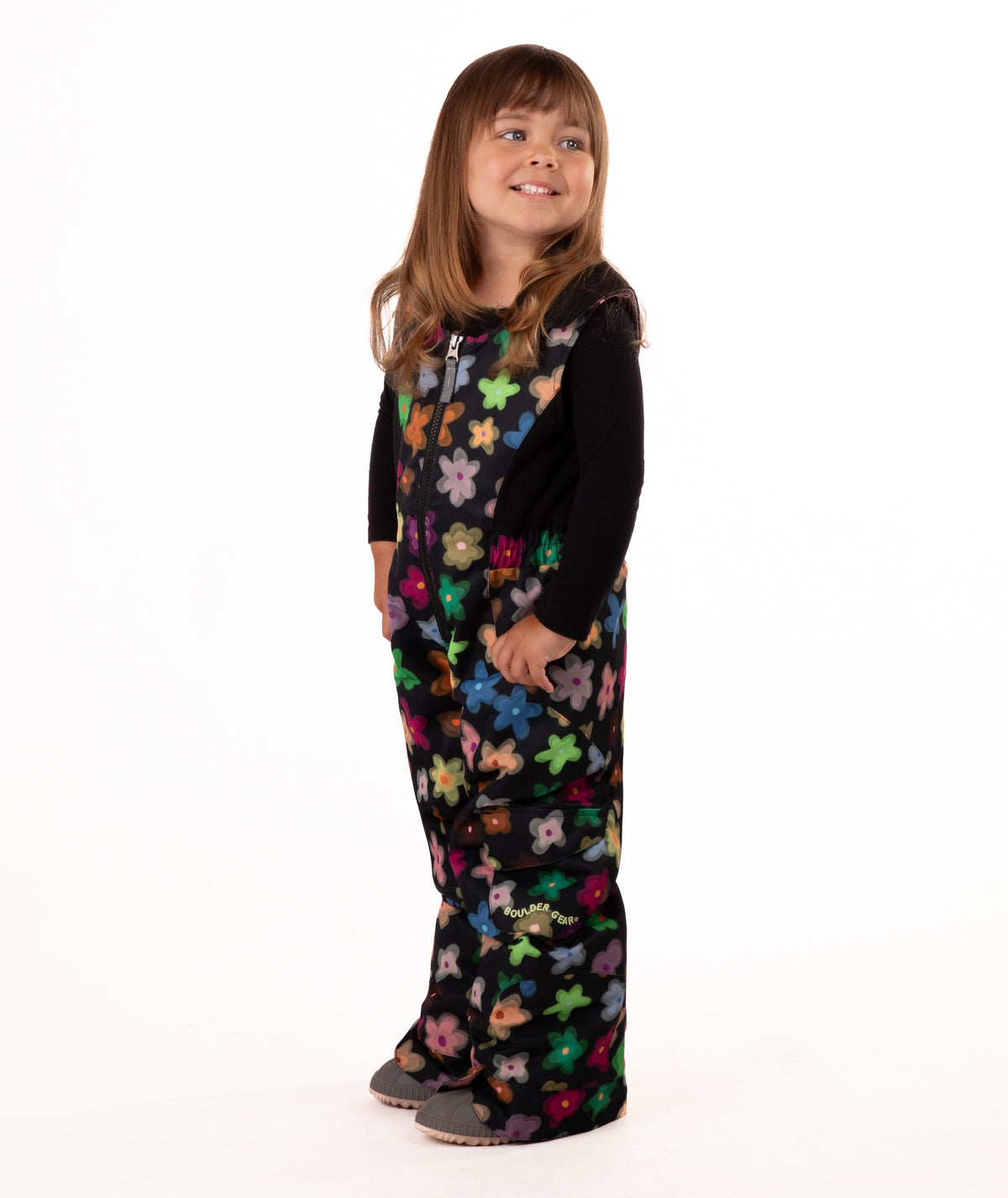 child wearing a multi color flower print snow bib with black top on a white background