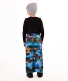 Child wearing colorful geometric print snow bibs on a white background highlighting the back of the bib